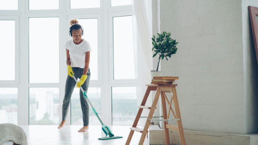 Woman mopping floor while listening to music.
